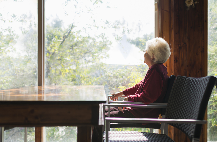 starsza kobieta patrząca w okno